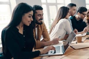 Groupe de personnes travaillant ensemble sur ordinateurs.