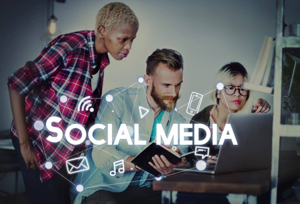 Équipe travaille sur réseaux sociaux sur ordinateur portable.
